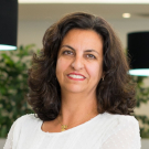 Dra. Helena Hachul de Campos em pé e sorrindo. Foto de perfil.